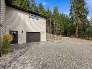 Discover this stunning property featuring a modern garage with a sleek dark door and a stylish horizontal window.