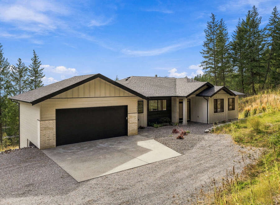 Discover this stunning modern home nestled amidst a serene, wooded landscape.