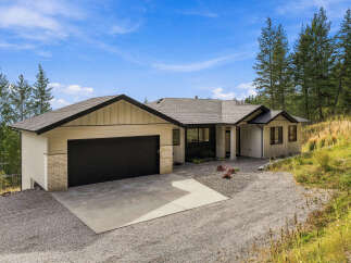Discover this stunning modern home nestled amidst a serene, wooded landscape.
