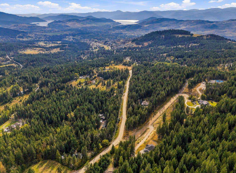 Experience luxury living nestled within a private, wooded estate offering breathtaking panoramic views of the valley and distant mountains.