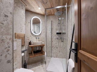 Experience rustic luxury in this charming bathroom, featuring a modern walk-in shower with dual showerheads and a sleek glass enclosure.