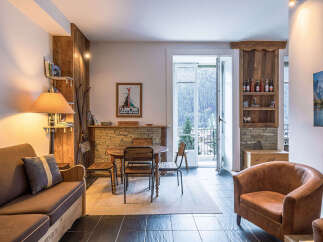 Experience cozy mountain living in this charming apartment, featuring a rustic wooden interior and a warm, inviting ambiance.