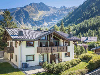 Experience alpine living in this charming chalet, nestled against a backdrop of majestic mountains and lush forests.