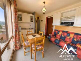 This charming studio apartment features a compact kitchenette with ample cabinet space, perfect for preparing meals.