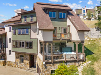 Experience luxury mountain living in this stunning property featuring a private hot tub on the deck, perfect for relaxing after a day of adventure.