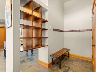 This entryway features a stylish wooden shelving unit, perfect for displaying decor or storing essentials.