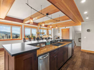 Experience luxury mountain living in this stunning kitchen featuring rich wood cabinetry, granite countertops, and a spacious island perfect for entertaining.