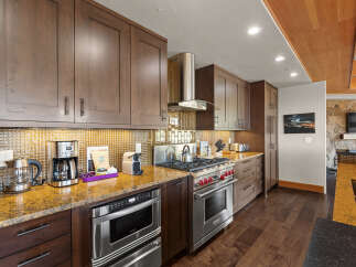 Experience culinary excellence in this stunning kitchen, featuring rich wood cabinetry and sleek stainless steel appliances.