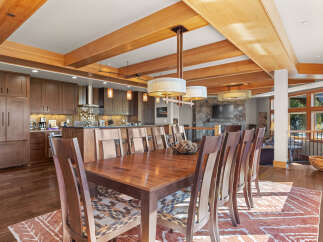 Experience elegant dining in this spacious room, featuring a large wooden table with uniquely patterned chairs, perfect for hosting gatherings.