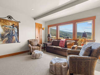 Experience breathtaking mountain views from this cozy living room, featuring a comfortable sofa and armchairs perfect for relaxing.