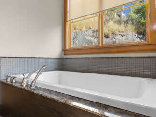 Indulge in relaxation with this luxurious bathtub, featuring elegant chrome fixtures and a stunning marble surround.