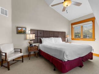 Experience comfort and style in this charming bedroom, featuring a plush king-sized bed with a rich brown tufted headboard.