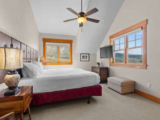 Experience breathtaking mountain views from this charming bedroom, featuring a comfortable king-size bed and a cozy seating area.