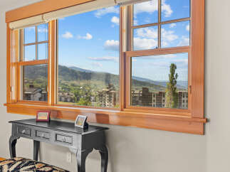 Experience breathtaking mountain views from this stunning property, framed by large, wood-trimmed windows.