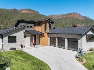 Experience modern mountain living in this stunning home featuring a striking architectural design with stone and wood accents.