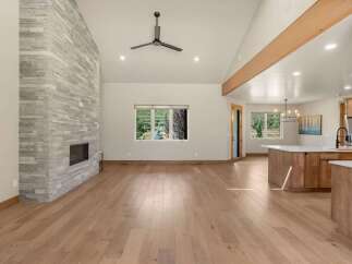 Experience modern living in this spacious open-concept home, featuring a stunning floor-to-ceiling stone fireplace as the centerpiece of the living area.
