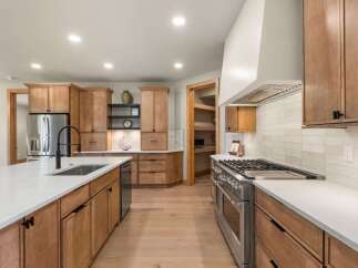 Experience the epitome of modern living in this stunning kitchen, featuring sleek stainless steel appliances, custom wood cabinetry, and a spacious island perfect for entertaining.