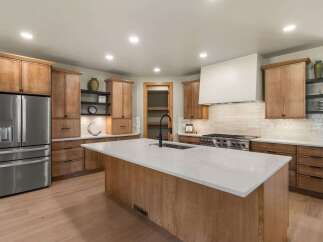 Experience luxury in this stunning modern kitchen, featuring sleek stainless steel appliances and ample custom wood cabinetry.