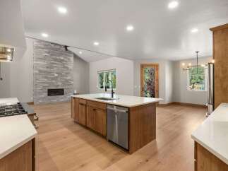 Experience modern living in this spacious open-concept kitchen and living area, featuring a stunning stone fireplace and a large island perfect for entertaining.