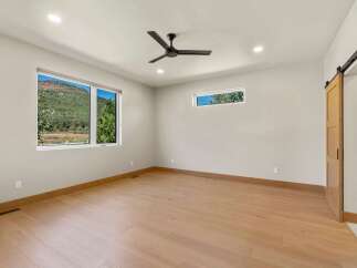 Experience breathtaking mountain views from this spacious bedroom, featuring large windows that flood the room with natural light.