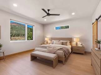 Experience serene living in this beautifully appointed bedroom, featuring a king-size bed with plush bedding and a stylish upholstered headboard.