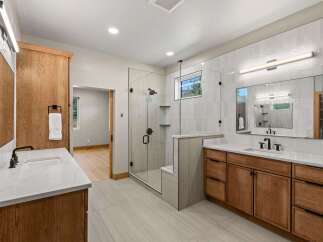 Experience luxury in this modern bathroom featuring a spacious walk-in shower with sleek glass doors and a built-in bench.