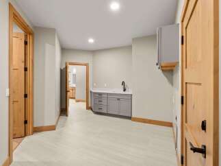 Discover this beautifully finished basement featuring a convenient wet bar with ample cabinet space and a sleek countertop, perfect for entertaining.