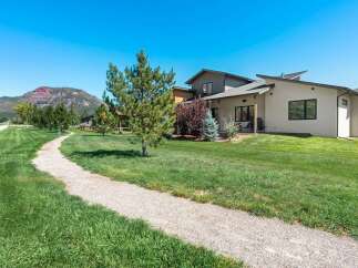 Discover this stunning modern home nestled amidst breathtaking mountain views and lush green landscapes.