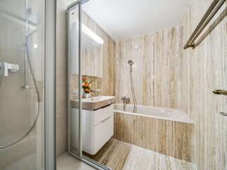 This modern bathroom features a sleek shower enclosure and a stylish vanity with ample storage.