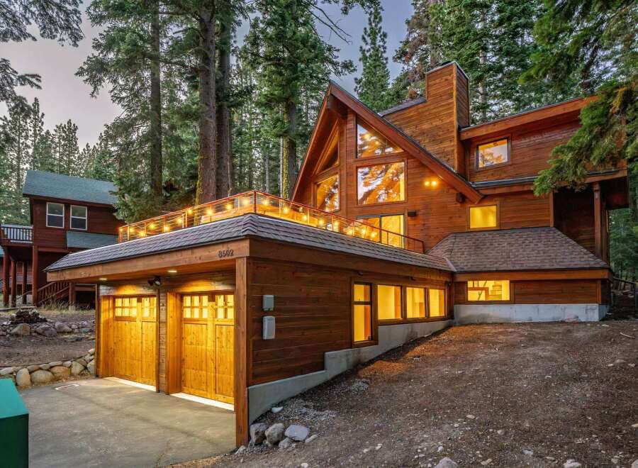 Nestled amidst towering trees, this stunning wooden A-frame home offers a luxurious mountain retreat.