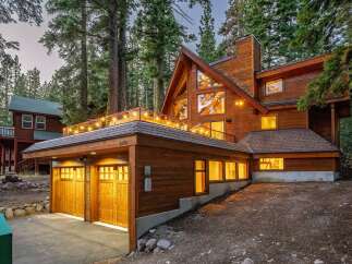 Nestled amidst towering trees, this stunning wooden A-frame home offers a luxurious mountain retreat.
