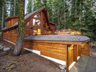 Nestled amidst towering pine trees, this stunning wooden mountain home offers a luxurious retreat.