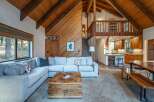 Experience rustic charm in this spacious living area, featuring a large sectional sofa perfect for gatherings and a unique wooden trunk coffee table.