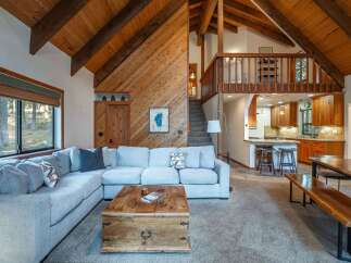 Experience rustic charm in this spacious living area, featuring a large sectional sofa perfect for gatherings and a unique wooden trunk coffee table.
