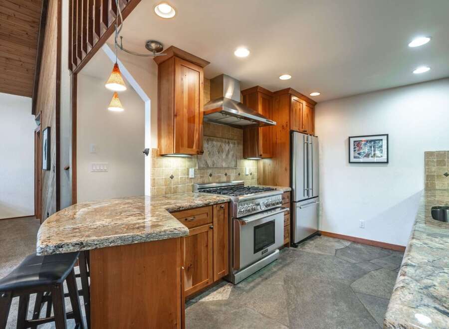 Experience the heart of this home with a stunning kitchen featuring rich wood cabinetry and a sleek stainless steel range.