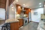 Experience the heart of this home with a stunning kitchen featuring rich wood cabinetry and a sleek stainless steel range.