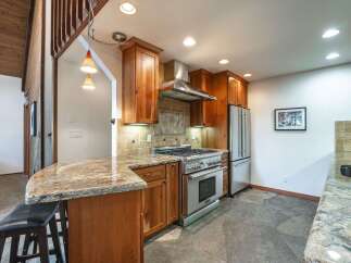 Experience the heart of this home with a stunning kitchen featuring rich wood cabinetry and a sleek stainless steel range.