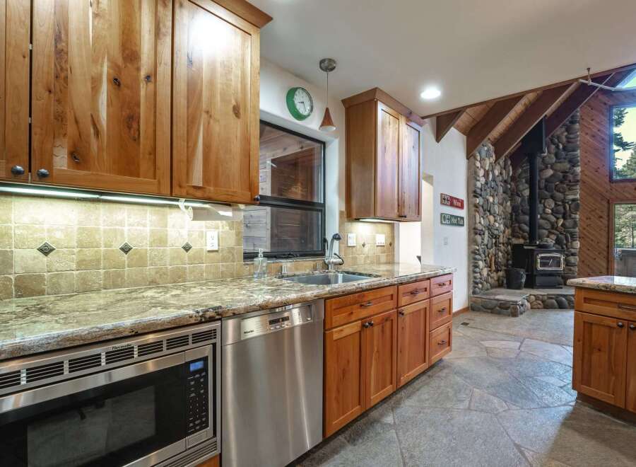 This stunning kitchen boasts custom wood cabinetry and granite countertops, perfect for a gourmet chef.