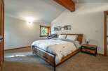 Experience rustic charm in this inviting bedroom, featuring a comfortable bed with a unique tree-patterned duvet and matching pillows.