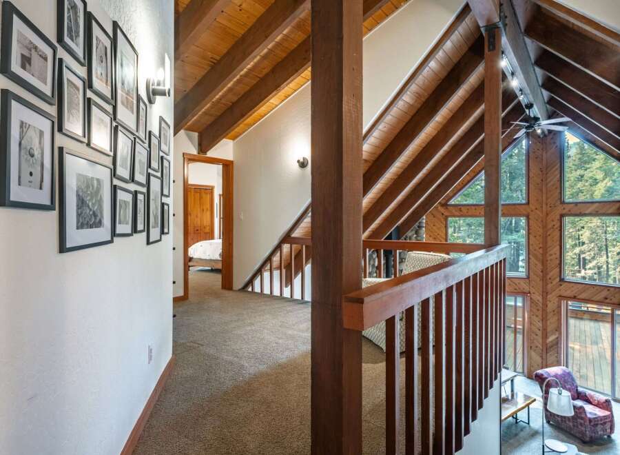 Ascend to a lofted haven featuring a stunning vaulted ceiling with exposed wooden beams, creating an airy and rustic ambiance.