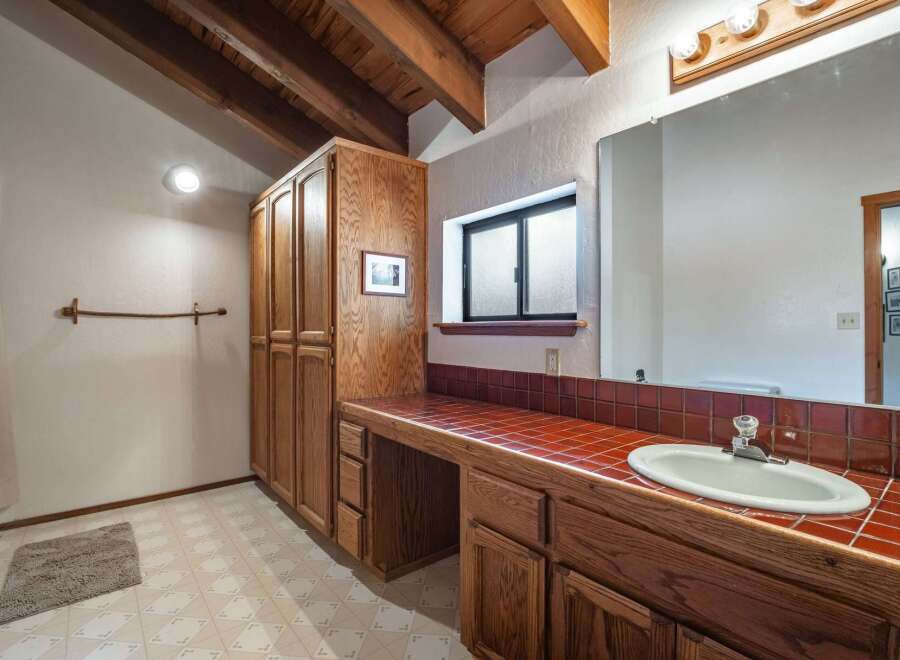 This charming bathroom features a spacious vanity with a tiled countertop and ample storage, perfect for organizing your essentials.