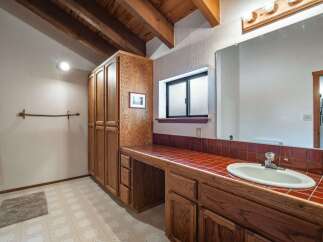 This charming bathroom features a spacious vanity with a tiled countertop and ample storage, perfect for organizing your essentials.