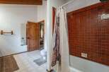 This rustic bathroom features a charming wooden door and exposed beams, adding a touch of natural warmth.