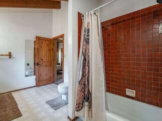 This rustic bathroom features a charming wooden door and exposed beams, adding a touch of natural warmth.