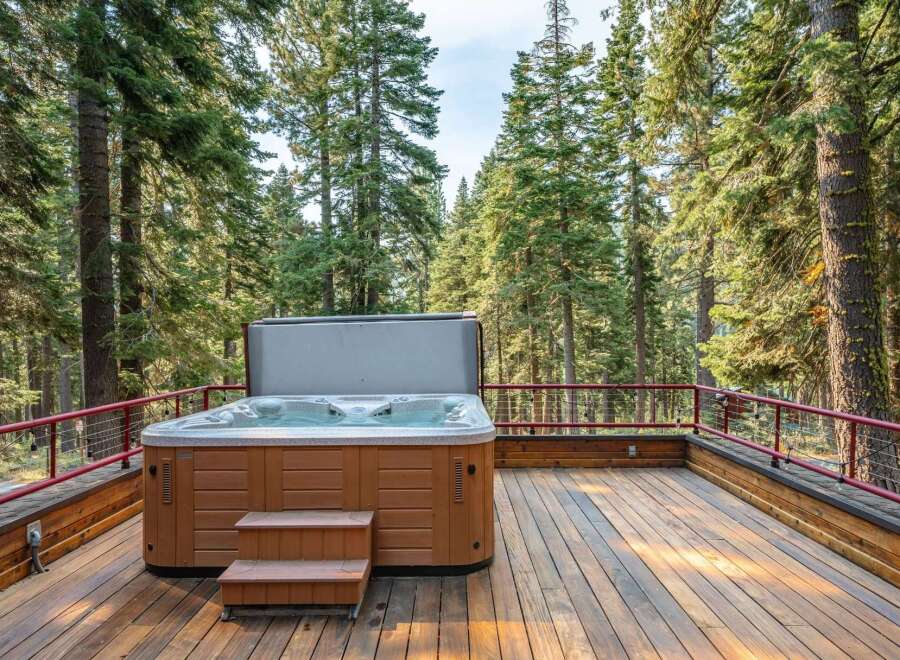 Experience ultimate relaxation in this secluded hot tub, nestled amongst towering pine trees.