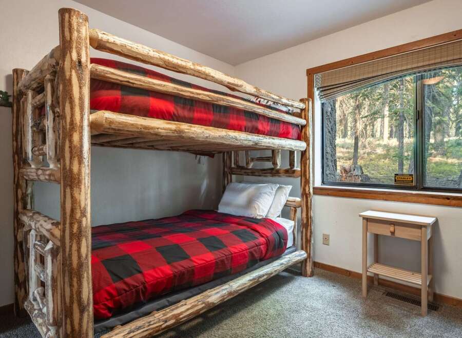 Experience rustic charm with this cozy bunk bed featuring a classic red and black buffalo plaid comforter.