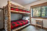 Experience rustic charm with this cozy bunk bed featuring a classic red and black buffalo plaid comforter.