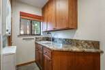 This laundry room features a convenient built-in sink and ample storage with custom wooden cabinetry.