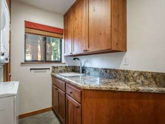 This laundry room features a convenient built-in sink and ample storage with custom wooden cabinetry.
