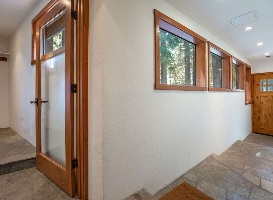 Step into this charming entryway featuring a beautiful wooden door with glass panes, inviting natural light into the space.